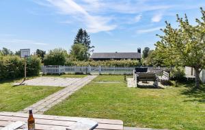 a backyard with a white fence and a basketball hoop at Amazing Home In Bogø By With Wifi in Bogø By +15 photos