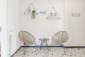 2 Stühle und ein Tisch in einem Zimmer mit weißen Wänden in der Unterkunft H11 AI CASTELLETTI Mare - Parcheggio in Arma di Taggia