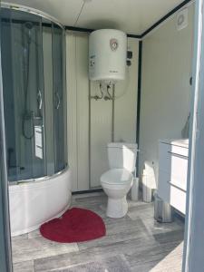 a bathroom with a tub and a toilet and a shower at Naturnära Fritidsboende, Tomtebo - YinTorp in Arkelstorp