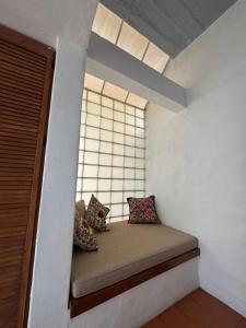 a small window seat with pillows in a room at Habitación en casa panoramica in Morelia +7 photos