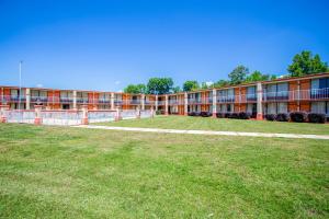 un edificio con un campo de césped delante de él en OYO hotel Greensboro east I 40, en Greensboro