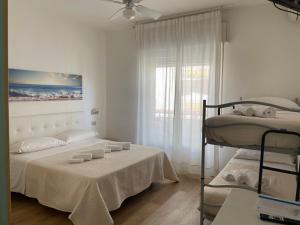 sypialnia z dwoma łóżkami piętrowymi i oknem w obiekcie Hotel Barbiani w mieście Riccione