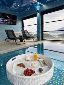 a room with a pool with a table with food on it at S-Penthouse in Herceg-Novi