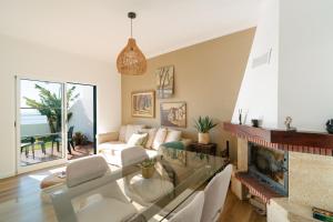 a living room with a glass table and a fireplace at Sunrise House by Wanderlust Madeira - 2 Bedroom Sea View in Gaula