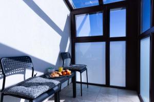 ein Balkon mit zwei Stühlen und einem Obstteller auf einem Tisch in der Unterkunft La Piazza Hotel in Schumen