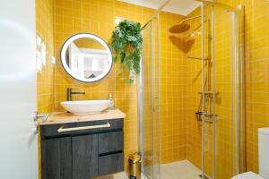 a yellow tiled bathroom with a sink and a shower at Sunrise House by Wanderlust Madeira - 2 Bedroom Sea View in Gaula +38 photos