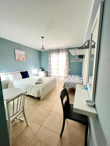 a bedroom with two beds and a table and a chair at Blue Tide - Tropea in Tropea