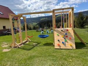 une aire de jeux avec toboggan et mur d'escalade dans l'établissement Doboszowka, à Lasowka