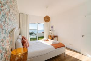 a bedroom with a bed and a large window at Sunrise House by Wanderlust Madeira - 2 Bedroom Sea View in Gaula