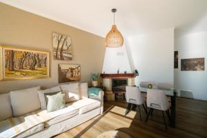 a living room with a couch and a table with chairs at Sunrise House by Wanderlust Madeira - 2 Bedroom Sea View in Gaula