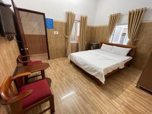 a bedroom with a bed and a table and a chair at Thiên Nam Motel Đà Nẵng in Danang