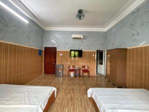a room with two beds and a flat screen tv at Thiên Nam Motel Đà Nẵng in Danang