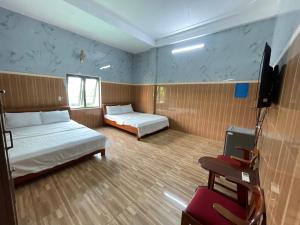 a room with two beds and a flat screen tv at Thiên Nam Motel Đà Nẵng in Danang