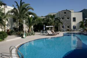 Una gran piscina con palmeras y un edificio. en Bella Garden Hotel, en Bodrum City