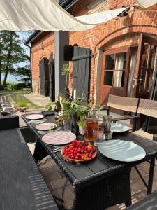 a table with plates and a bowl of fruit on it at Za Lasem Nad Wodą in Narty