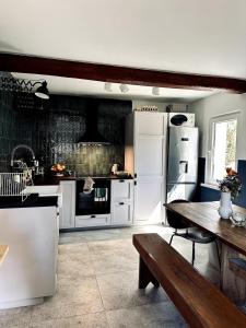 a kitchen with white appliances and a wooden table at Za Lasem Nad Wodą in Narty