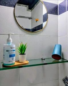 a bathroom shelf with a bottle of soap and a mirror at Daisy in Nafplio +25 photos