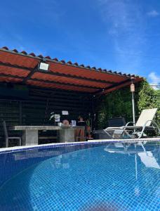 a swimming pool with two chairs and a pavilion at Residencia Esmeralda in Agua Buena