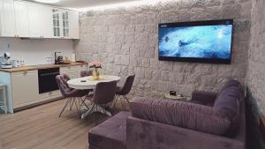 a living room with a couch and a tv on a wall at Garma in Slatine
