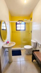 a yellow bathroom with a toilet and a sink at 4 Estações - Arraial in Arraial do Cabo