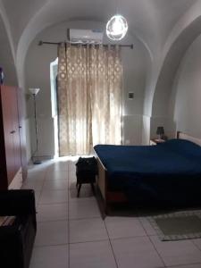 a bedroom with a bed with a blue blanket and a window at Modern Studio in Catania with Air Conditioning in Catania