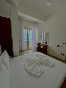 a white bed with a flower decoration on it at Blue Paradise Hotel in Orikum