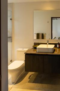 a bathroom with a sink and a toilet and a mirror at Pacifica by Pardela in Bucerías +108 photos