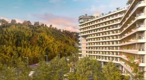 a large building with a mountain in the background at Bamboo Beach Tsikhisdziri in Ts'ikhisdziri