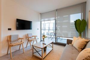 a living room with a couch and a table at Las Condes Living Arauco Park Gourmet Couple's Pad in Santiago +40 photos