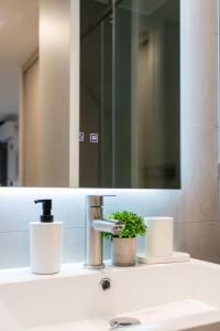 a bathroom sink with a mirror and a faucet at Las Condes Living Arauco Park Gourmet Couple's Pad in Santiago