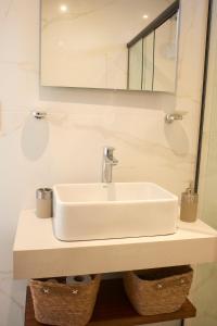Un lavabo blanco en un baño con espejo. en Movistar Arena, calidez y confort, en Buenos Aires 19 fotos más