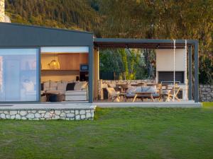 een huis met een patio met een schommel bij Anemones Villas by Omikron Selections in Spanokhórion