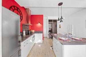 ボーヌにあるLe Beau Carnot - Appartement en Hypercentre de Beauneの白いキャビネットと赤い壁のキッチン