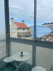 a table and two chairs in a room with windows at L'Echappée Quennoise, Appartement à 200m de la mer in Quend-Plage