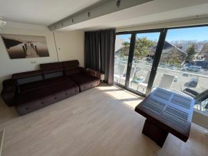 a living room with a couch and a large window at Palanga poilsiui in Palanga