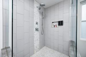 a bathroom with a shower with white tiles at Indy Getaway - 5BR - Sleeps 16 - Arcade games - Perfect for families and groups in Indianapolis +87 photos