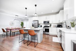 a kitchen with white cabinets and a table with chairs at Indy Getaway - 5BR - Sleeps 16 - Arcade games - Perfect for families and groups in Indianapolis