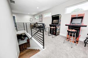 a room with two arcade games and a staircase at Indy Getaway - 5BR - Sleeps 16 - Arcade games - Perfect for families and groups in Indianapolis