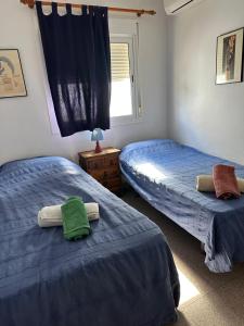 a bedroom with two beds with towels on them at Casa Barbados in Agua Amarga +13 photos