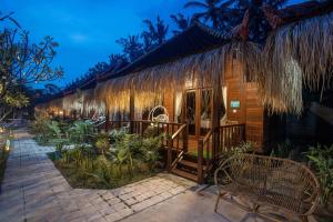 un complexe hôtelier avec un toit de chaume la nuit dans l'établissement Alinn Villas, à Nusa Lembongan 70 autres photos
