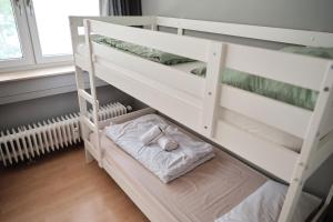 a white bunk bed with two pillows on it at Spacious Flat by the Rhine Ideal for Groups in Neuss