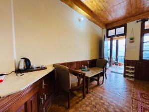 a dining room with a wooden table and chairs at Sharda House in Manāli