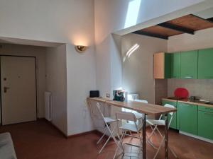 a kitchen with green cabinets and a table and chairs at Il Loggiato del Corso in Città di Castello