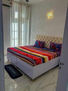 a bedroom with a bed in a room with a window at Nature Homes 2 bhk independent Flat in Dehradun