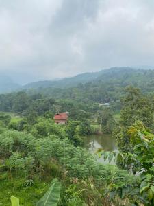 a small house on a hill next to a river at Hà Giang Lake View House in Lan Hung