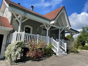 a house with a white fence and flowers at TULIPES Et CETERA in Waldighofen