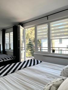 a bedroom with a bed with striped pillows and windows at U Borsuków in Pobierowo