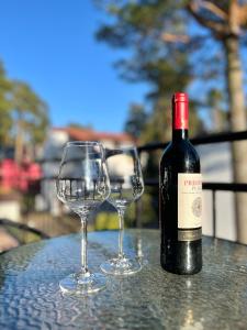 a bottle of wine and two glasses on a table at U Borsuków in Pobierowo