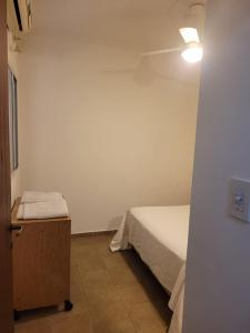ein kleines Schlafzimmer mit einem Bett und einem Deckenventilator in der Unterkunft Urquiza in Santa Fe