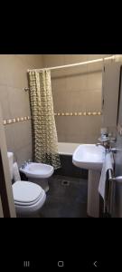 ein Badezimmer mit Toilette, Waschbecken und Badewanne in der Unterkunft Urquiza in Santa Fe + 7 Fotos